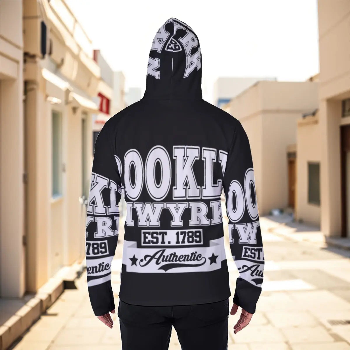 Man wearing a Brooklyn-themed hoodie with graphic text, standing in an urban setting.