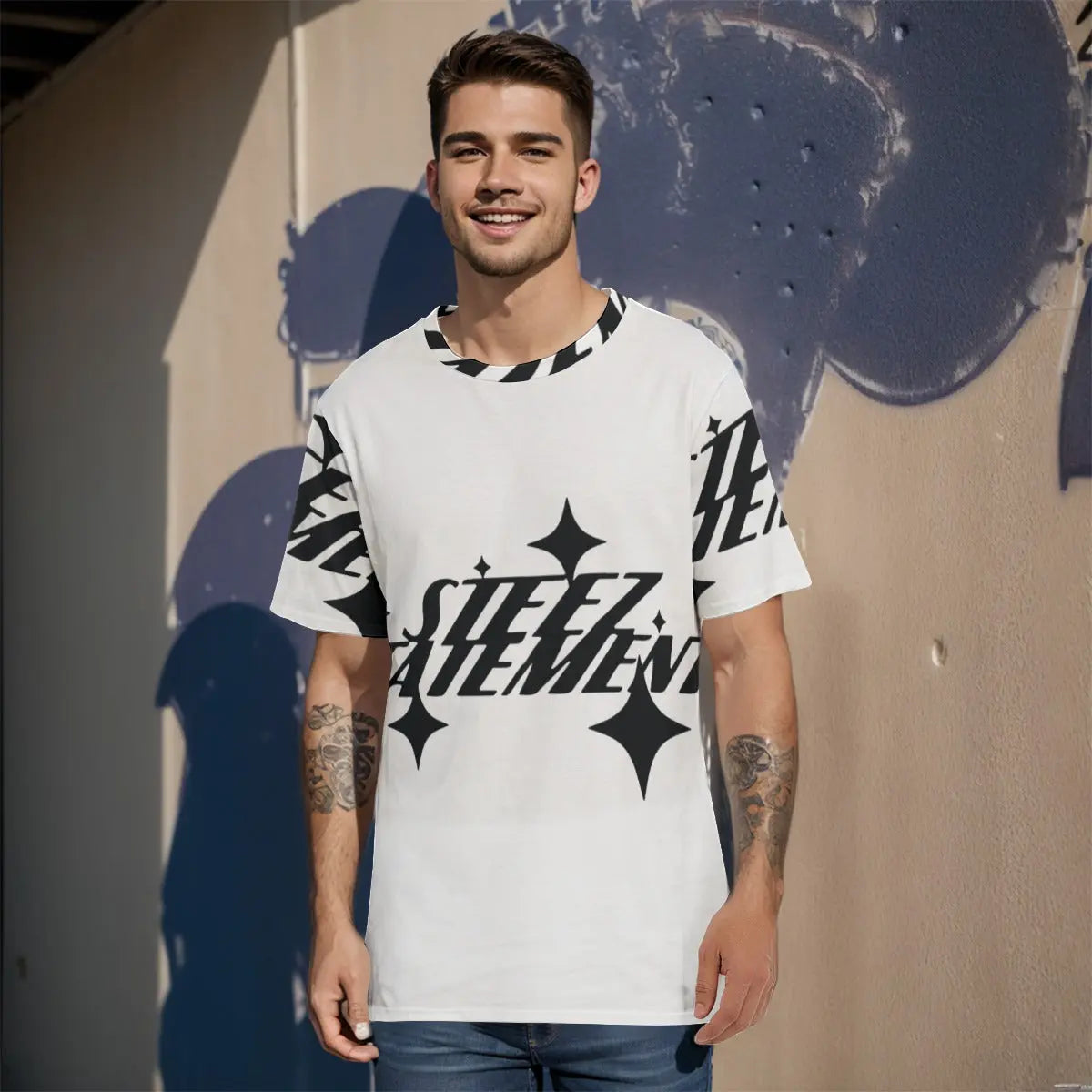 Man wearing a stylish black and white graphic T-shirt, standing against a textured wall