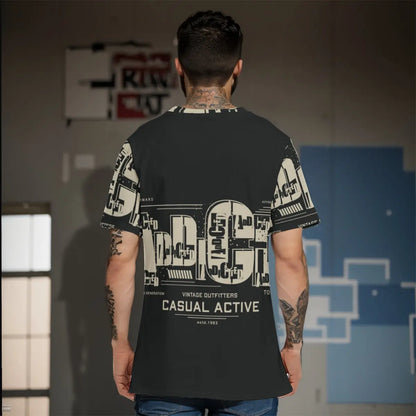 Man wearing a casual active graphic T-shirt with bold text and a unique design, standing indoors against a modern backdrop.