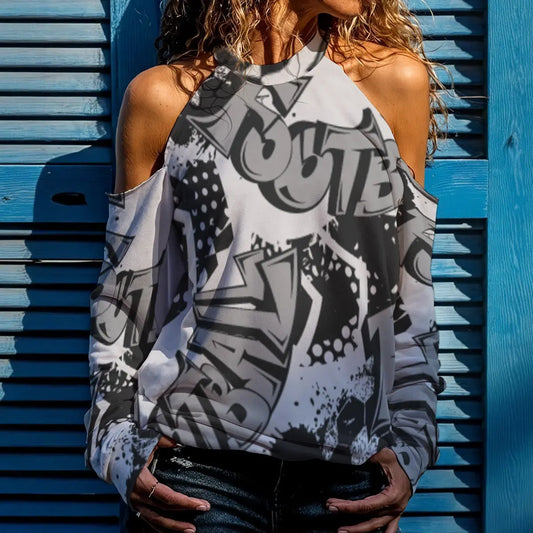 Woman wearing graffiti-patterned cutout shoulder jumper with high neck and cold shoulder design, perfect for casual stylish looks.