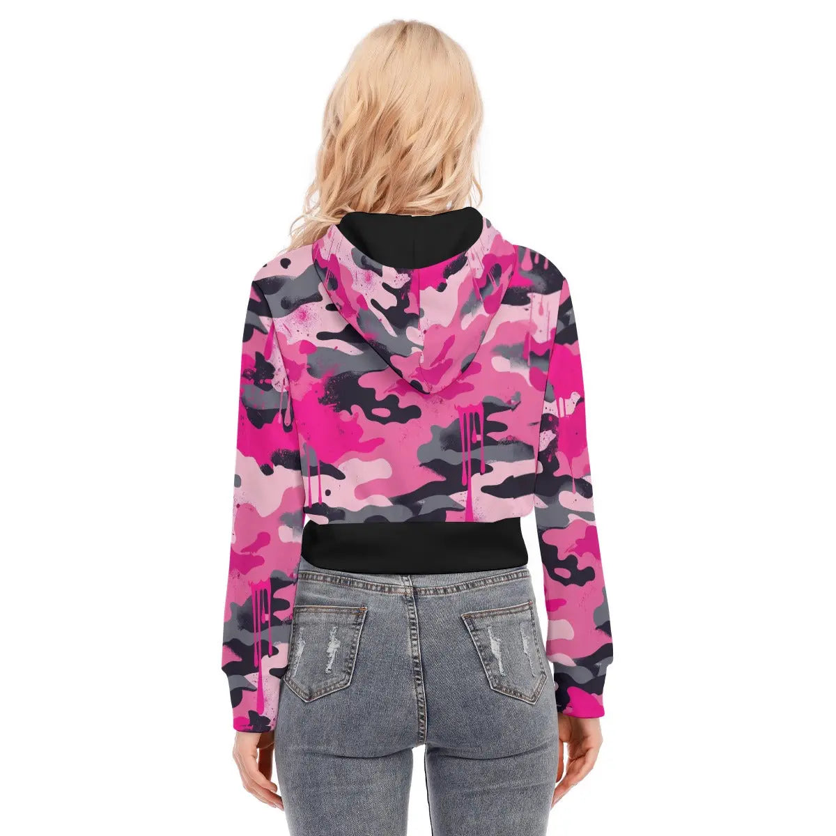 Back view of woman wearing a pink camo cropped jacket with long sleeves, paired with jeans.