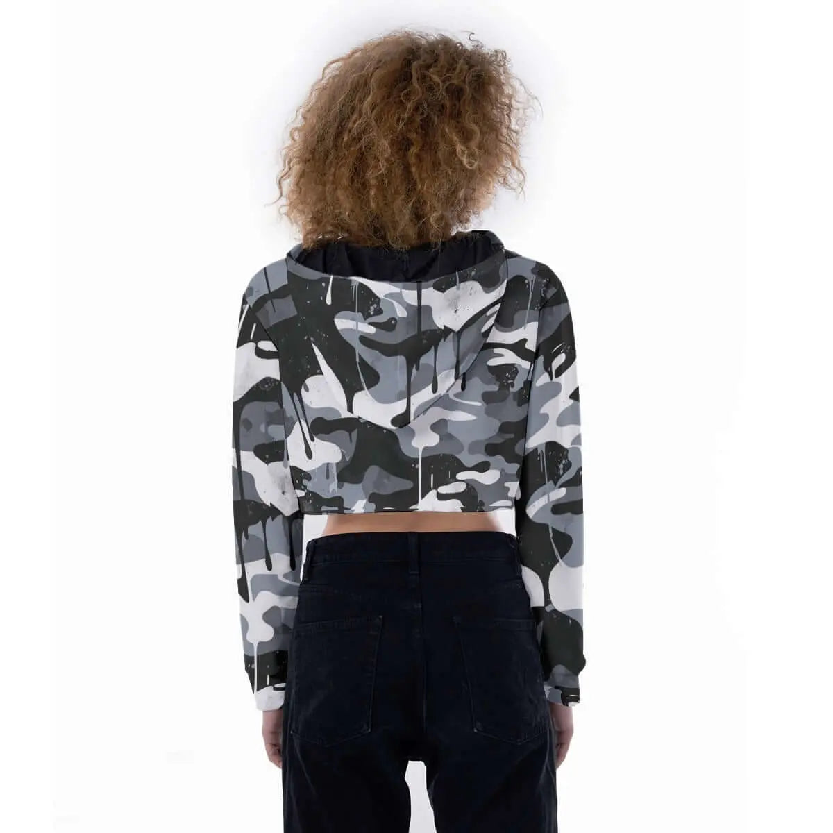Back view of a woman wearing a camo cropped hoodie with drop shoulders and drawstring hood, paired with black pants.